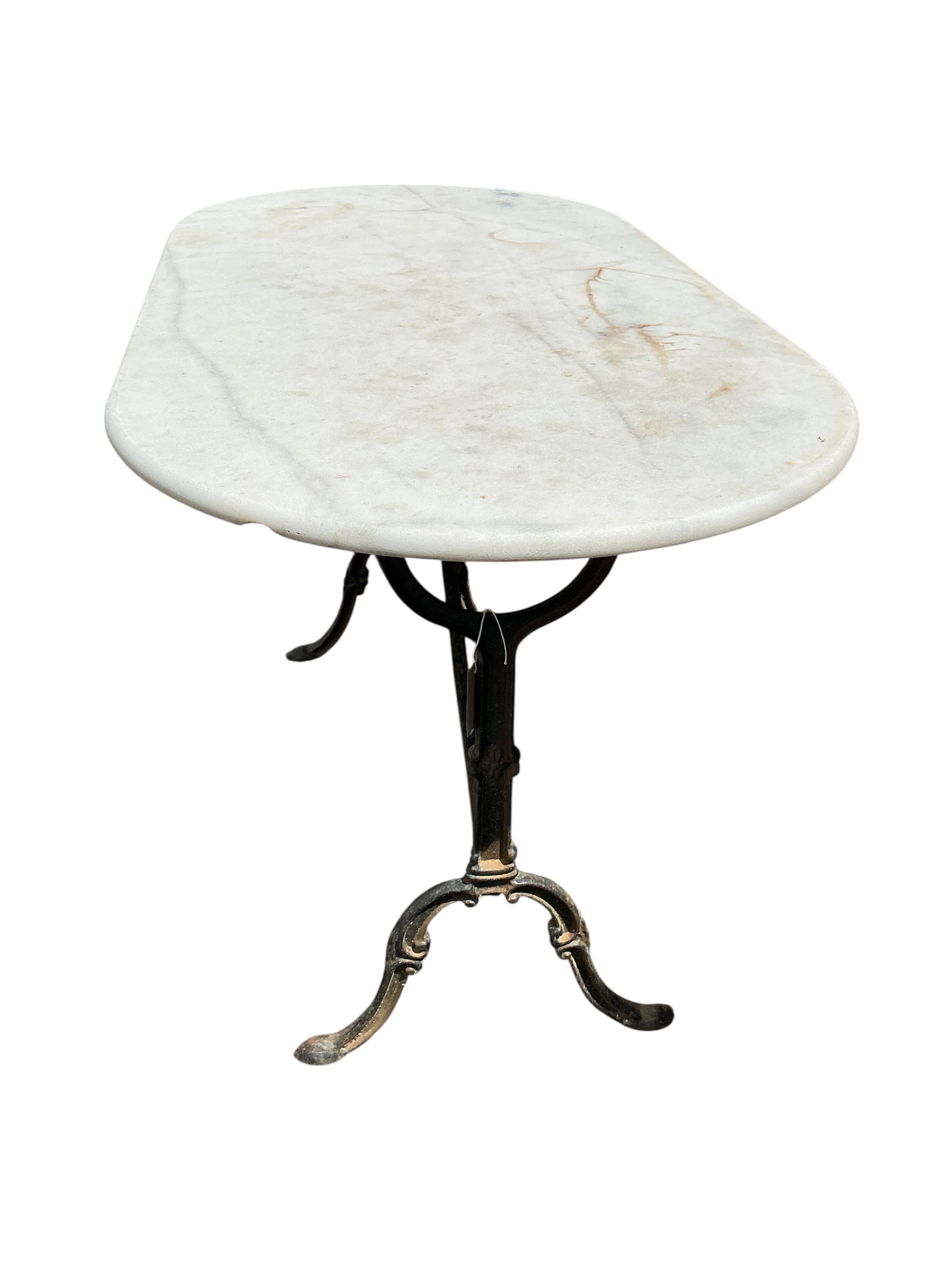 An oval reconstituted marble and cast iron garden table, width 120cm, depth 60cm, height 71cm